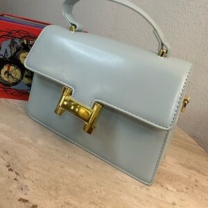 Elegant Light Blue Handbag with Gold Accents